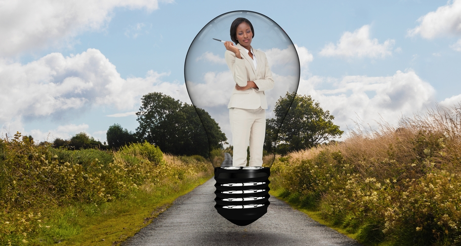 Businesswoman standing in bulb over road against sky - vectorfusionart - Depositphotos